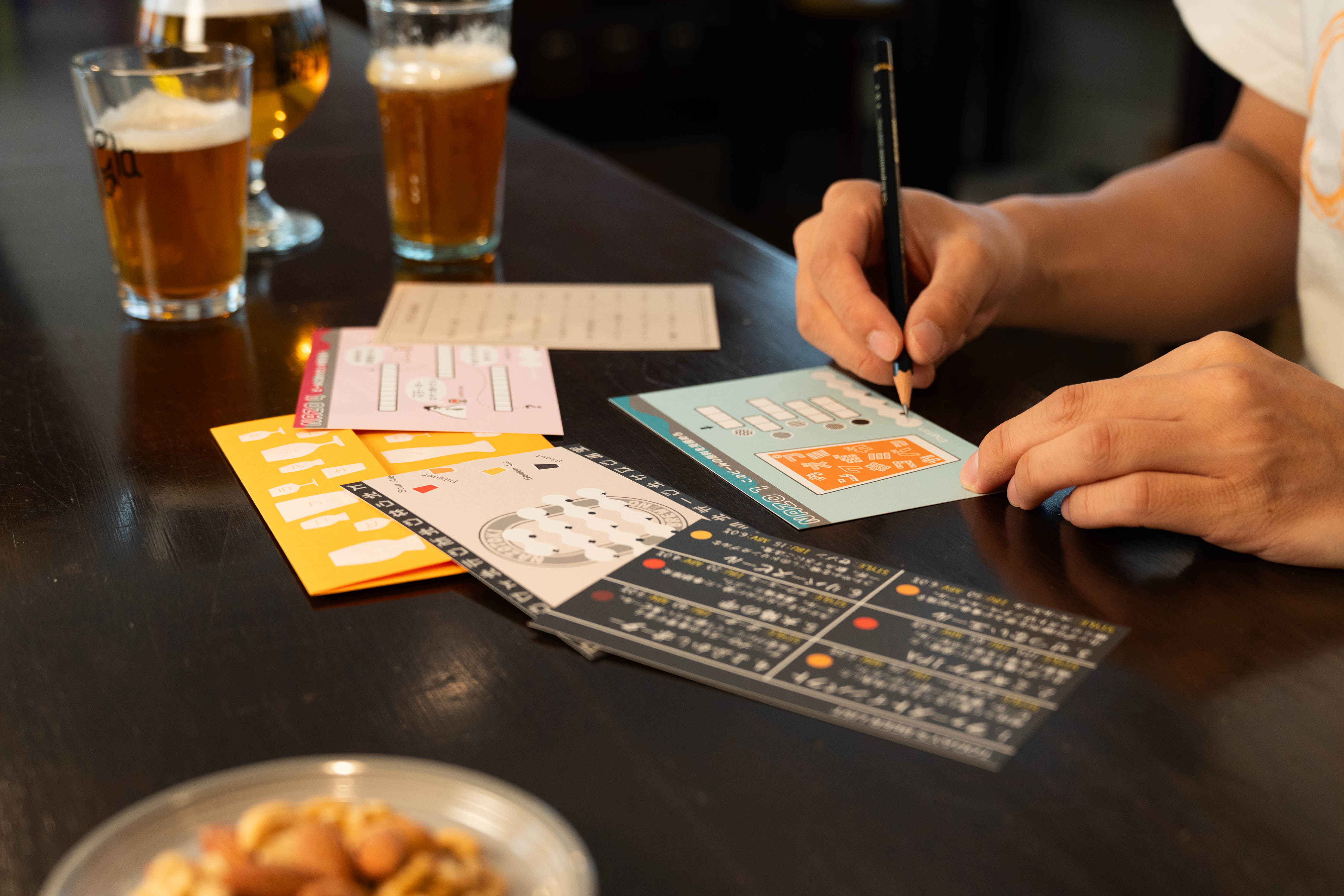 解くまで飲めないナゾトキブリューイング ビールとシートを並べたプレイ場面