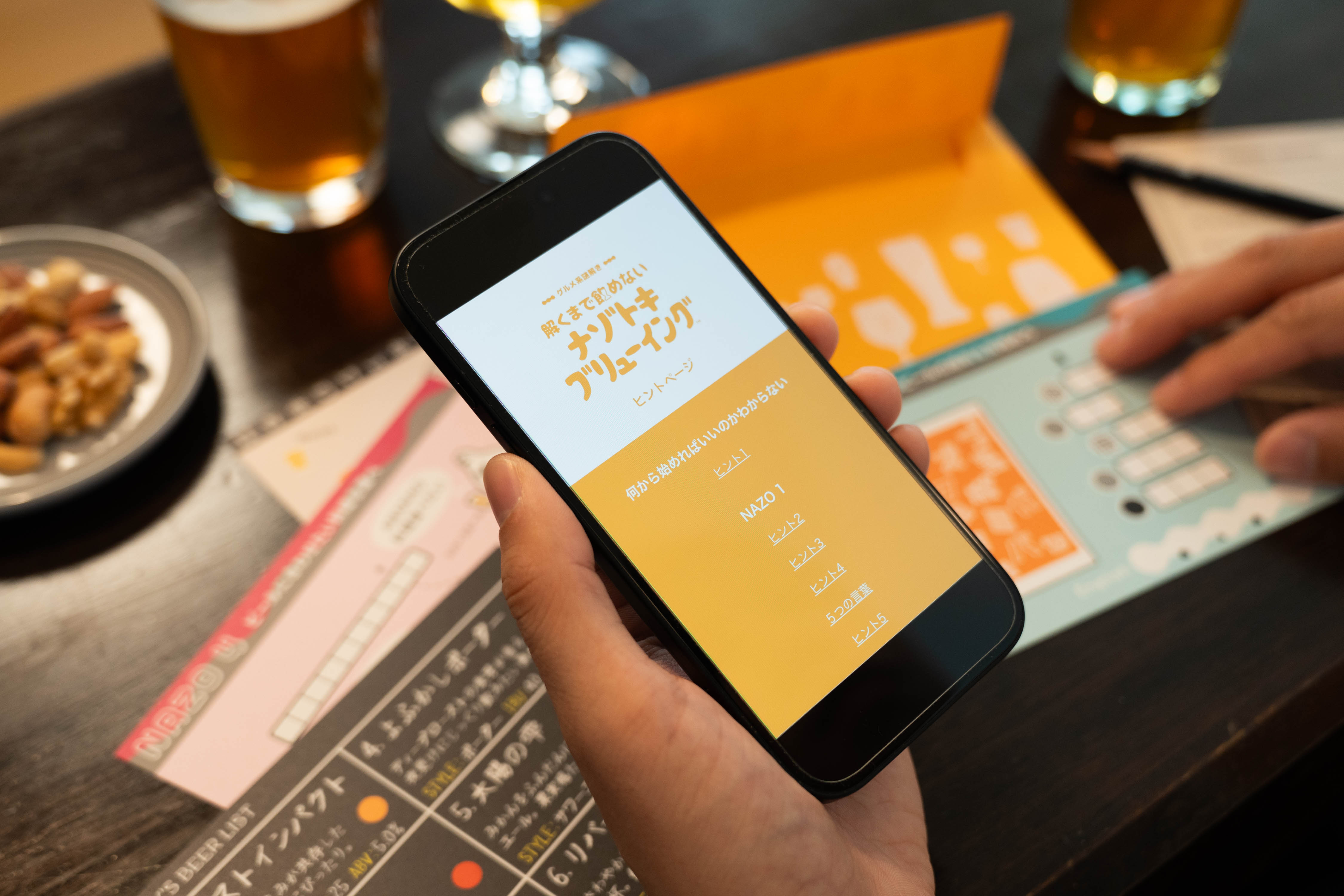解くまで飲めないナゾトキブリューイング スマートフォンに表示した段階式ヒント画面