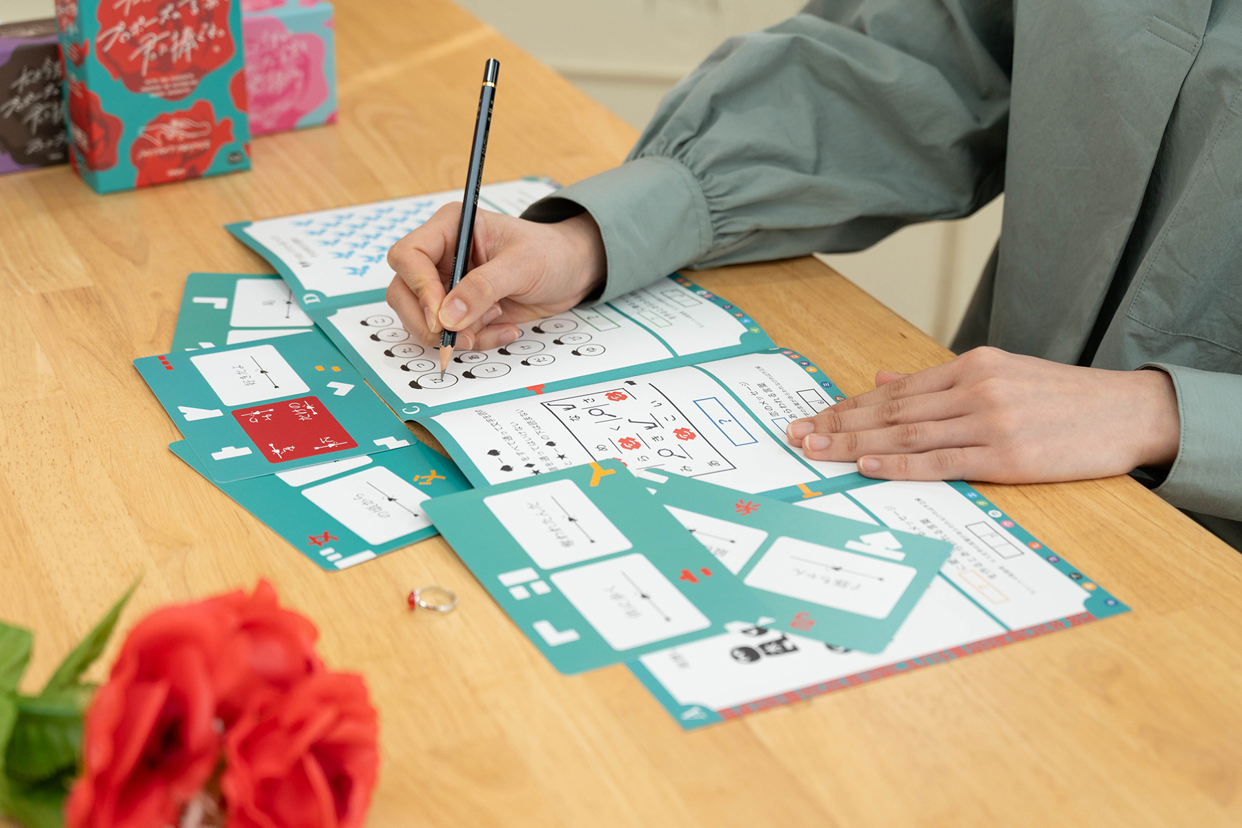 たった今考えたプロポーズの謎解きゲーム 筆記用具で謎解きシートに書き込む場面